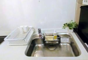 a kitchen sink with a dish drying rack next to it at Hachi Kamakura KOIWA in Tokyo