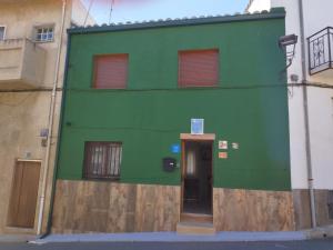 a green building with a door in front of it at CASA GORDON in Navaluenga