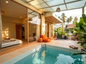 a villa with a swimming pool and a bedroom at Thara Pearl Villa in Ko Phangan