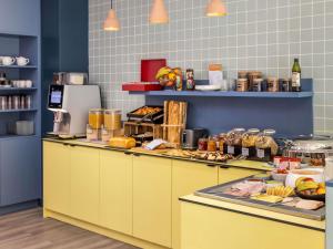 a kitchen with a yellow counter with food on it at Aparthotel Adagio Access Toulouse Jolimont in Toulouse +52 photos