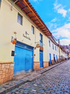 a building with blue doors on the side of a street at Hawka Inka hotel cusco in Cusco