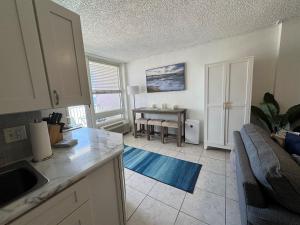 a kitchen and living room with a couch and a table at Direct ocean front view 1 bedroom 2 Pools in Daytona Beach