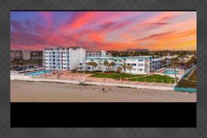 a view of a beach with buildings and a sunset at Direct ocean front view 1 bedroom 2 Pools in Daytona Beach +28 photos