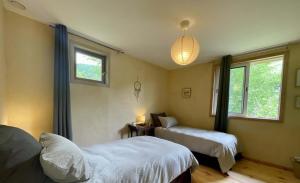 a bedroom with two beds and a window at Source Nature in Le Mas-dʼAzil