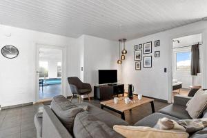 a living room with a couch and a table and a tv at bl1192-Blokhus-Holstvej-7 in Blokhus