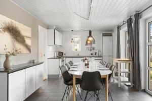 a kitchen and dining room with a table and chairs at bl1192-Blokhus-Holstvej-7 in Blokhus