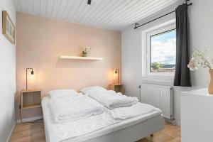 a white bedroom with a bed and a window at bl1192-Blokhus-Holstvej-7 in Blokhus +22 photos