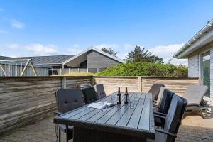 a wooden table and chairs on a patio at bl1192-Blokhus-Holstvej-7 in Blokhus