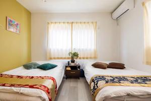 two beds in a room with a window at Hachi Kamakura KOIWA in Tokyo +49 photos