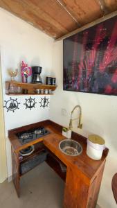 a kitchen with a sink and a stove at Suítes Recanto dos papagaios in Angra dos Reis