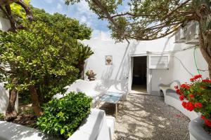 a white house with trees and flowers in a yard at Casa Colette in Anacapri