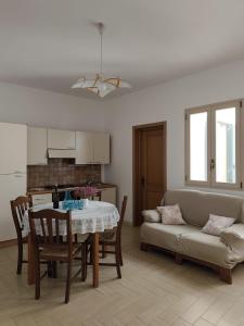 a kitchen and living room with a table and a couch at Passo lento in Leverano