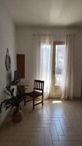 a room with a chair and a table and a window at Passo lento in Leverano