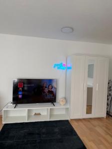 a living room with a flat screen tv on a white entertainment center at Gemütliche Ferienwohnung in Sigmaringen in Sigmaringen