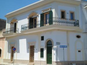 a white building with a balcony on top of it at Passo lento in Leverano