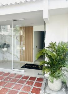 a house with glass doors and a potted plant at Hotel Galicia in Montería +8 photos