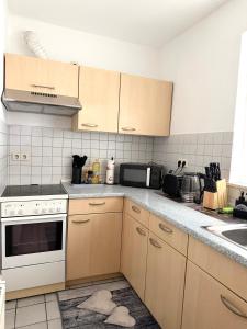 a kitchen with wooden cabinets and a counter top at Gemütliche Ferienwohnung in Sigmaringen in Sigmaringen +4 photos