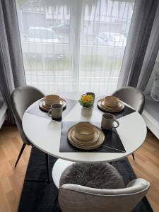 a white table with plates and cups on it at Gemütliche Ferienwohnung in Sigmaringen in Sigmaringen