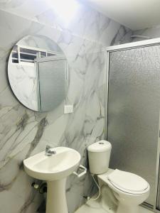 a bathroom with a toilet and a sink and a mirror at Hotel Galicia in Montería