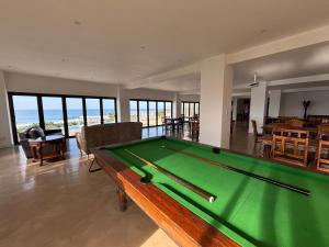a pool table in a living room with a view of the ocean at Gracelands Beach Lodge in Ramsgate