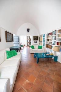 a living room with white furniture and bookshelves at Casa Colette in Anacapri