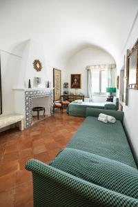 a living room with two green beds and a fireplace at Casa Colette in Anacapri