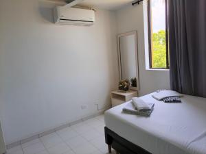 a bedroom with a bed with a mirror and a window at VILLA IRIS in Santa Marta