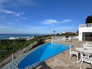 a swimming pool with a view of the ocean at Gracelands Beach Lodge in Ramsgate