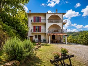 a large house with red windows and a bench at Casa vacanze "Ellen" - AAUT in Bianchi
