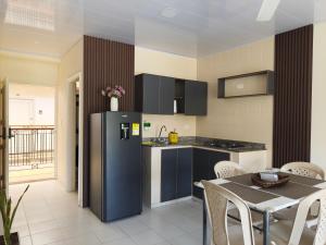 a kitchen with a refrigerator and a table with chairs at VILLA IRIS in Santa Marta