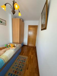a bedroom with a bed and a wooden floor at Apartamento Liencres in Liencres