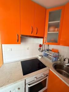 a kitchen with orange cabinets and a sink at Apartamento Liencres in Liencres +15 photos
