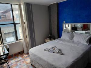 a bedroom with a large bed with a blue wall at Hotel Emmanuel in Chepén