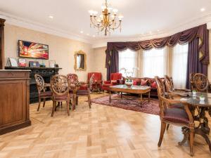 ein Wohnzimmer mit Sofa, Tisch und Stühlen in der Unterkunft Ashburn Hotel in London