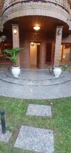 a building with two white pots in front of it at Monoambiente in Ezpeleta