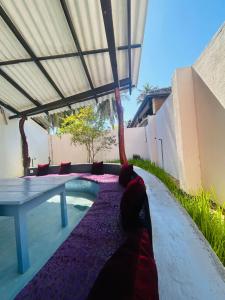 a patio with a table and a pool in it at AAA Happy Hostel in Arugam Bay