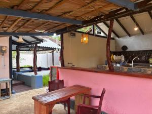 an outdoor bar with a wooden table and chairs at AAA Happy Hostel in Arugam Bay