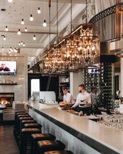 two men standing at a bar in a restaurant at Hotel Place D'Armes in Montreal