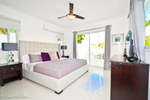 een slaapkamer met een bed en een plafondventilator bij The Sanctuary @ Los Corales in Punta Cana