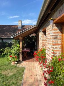 a brick patio with a picnic table and flowers at Anna Lak in Magyarszombatfa