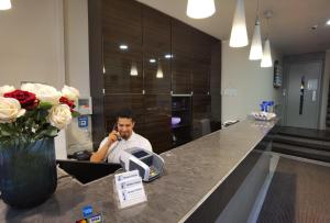 a man sitting at a counter talking on a cell phone at Hotel Italia in Munich
