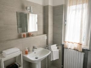 a white bathroom with a sink and a mirror at Via Milano 67 in Porto SantʼElpidio
