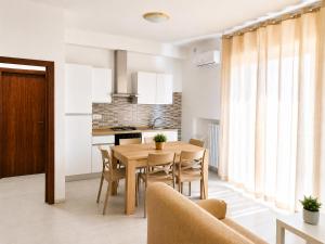 a kitchen and dining room with a wooden table and chairs at Via Milano 67 in Porto SantʼElpidio