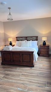 a bedroom with a large wooden bed with two lamps at Patricks Thatch Cottage in Oranmore