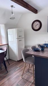 a kitchen with a table and a white refrigerator at Patricks Thatch Cottage in Oranmore +9 photos
