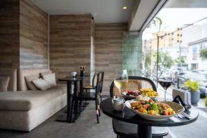 a table with a plate of food and glasses of wine at ARTE HOTEL Lima in Lima