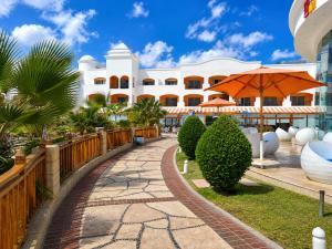 a large white building with an orange umbrella at Fun & Sun Naama Waves in Sharm El Sheikh