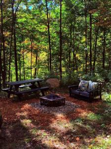 a picnic table and a couch in the woods at TinyHouse - Touski in Val-des-Lacs +9 photos