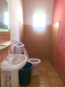 a bathroom with a toilet and a sink at Zen villa in Old Yundum +3 photos