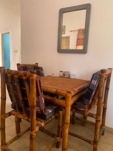 a wooden table with two chairs and a mirror at Zen villa in Old Yundum
